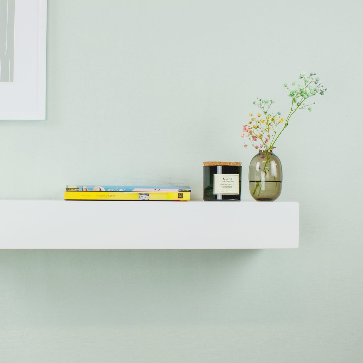 Slim white floating shelf with built-in drawer installed in a small bedroom, highlighting space-saving wall-mounted design